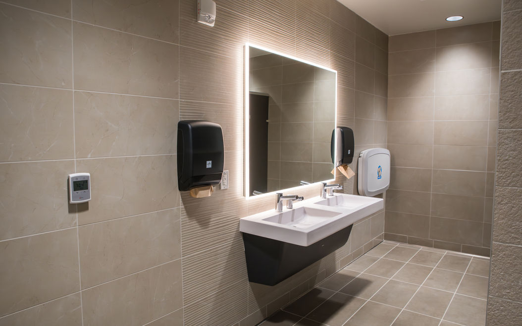 hospital bathroom with sink and mirror over beautiful tiling work
