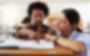 An image of a student working closely with a teacher in a classroom.