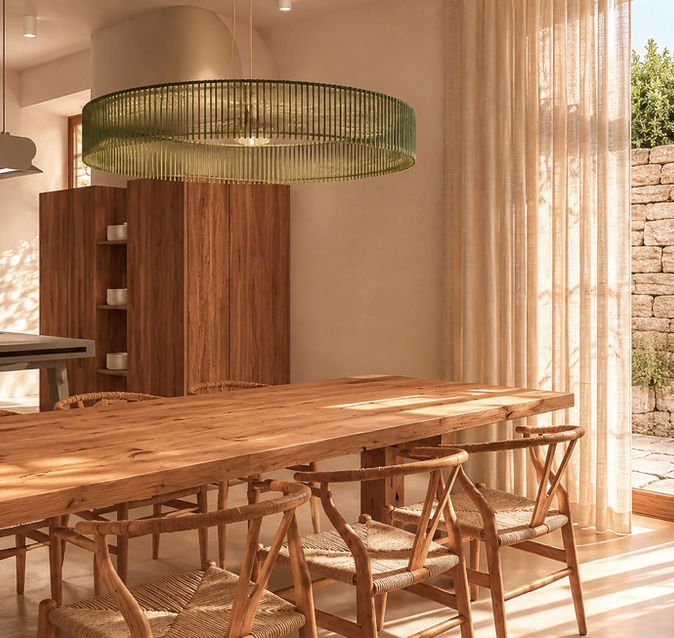 Salle à manger baignée de lumière avec grande table en bois massif, cuisine ouverte et matériaux naturels dans une ambiance méditerranéenne élégante.