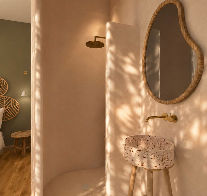 Salle d'eau en béton ciré avec douche à l'italienne arrondie, vasque en terrazzo et robinetterie en laiton dans une ambiance douce et naturelle.