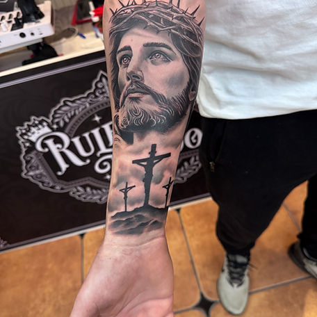 Rule tattoo tattoo of Jesus on forearm with three crosses below the portrait