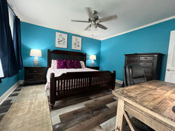 Large master bedroom with large tall chest of drawers for clothing storage.