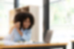 vecteezy_smiling-young-african-female-entrepreneur-sitting-at-a-desk_15128066_edited.jpg