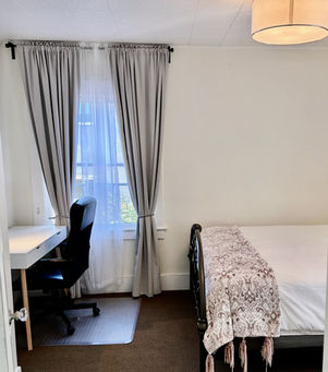 Bedroom 1 with queen size bed, night tables, lamps, desk, chair, two windows, dresser, bookcase