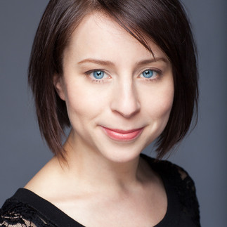 woman with black top and dark brown hair in a bob with natural makeup for headshot