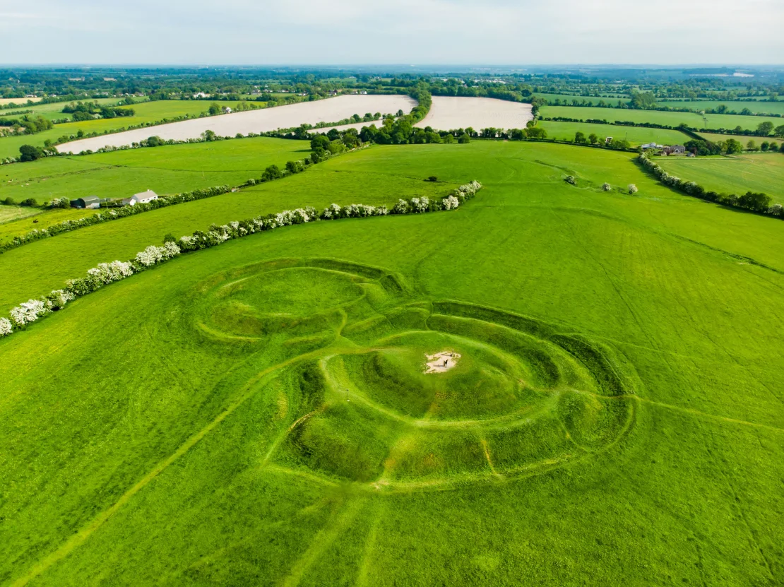 A scenic aerial view of the hill of Tara, surrounding by Irish green fields and stone fencesrepresenting Ireland’s green legacy.