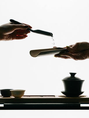 Two hands gracefully pouring water during a traditional tea ceremony, capturing the mindfulness and balance at the heart of creative ritual