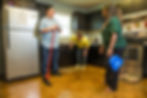 Three people cleaning in a kitchen