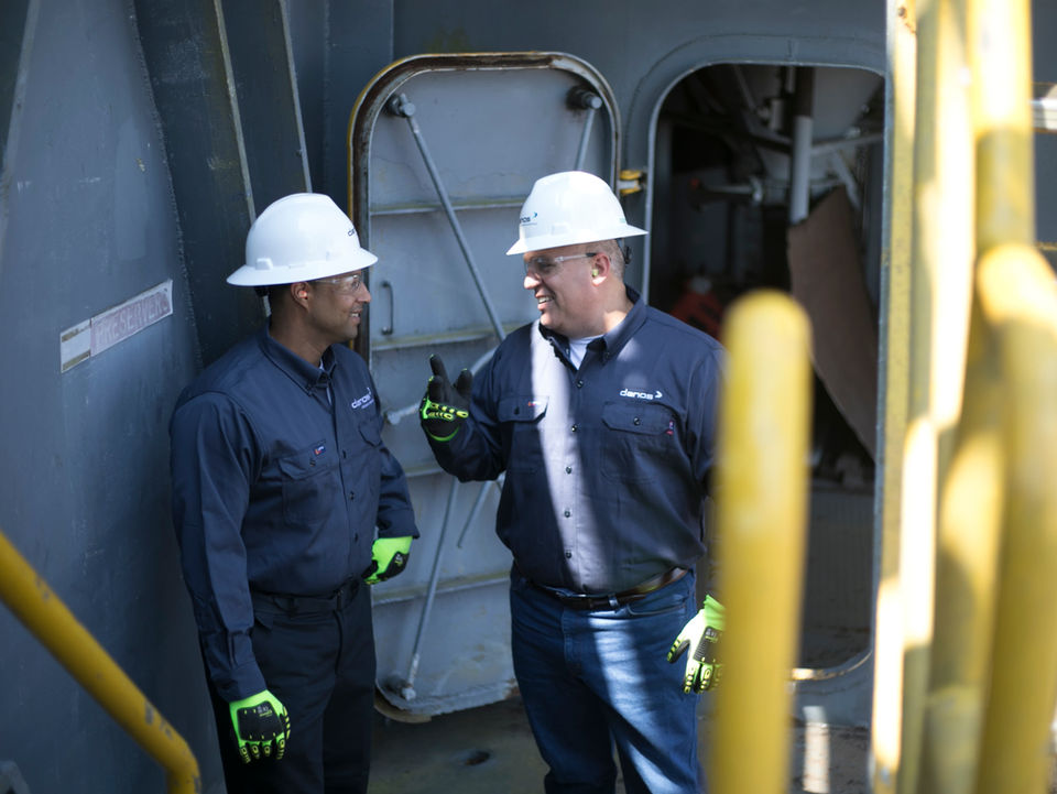 Two workers in hard hats conversing