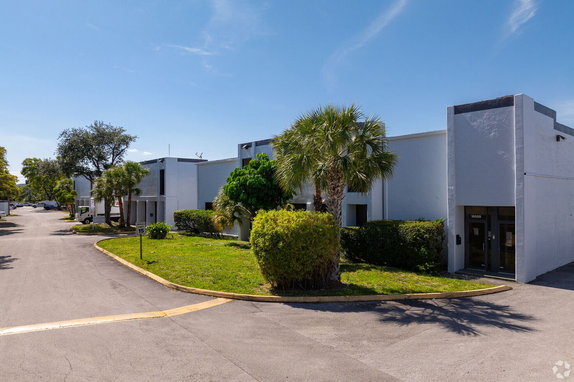 Palm trees and the exterior of an industrial space for rent in Miami at Aventura Industrial Park.