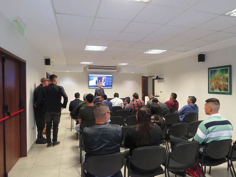 Grupo de personas en charla presencial en sala de conferencias
