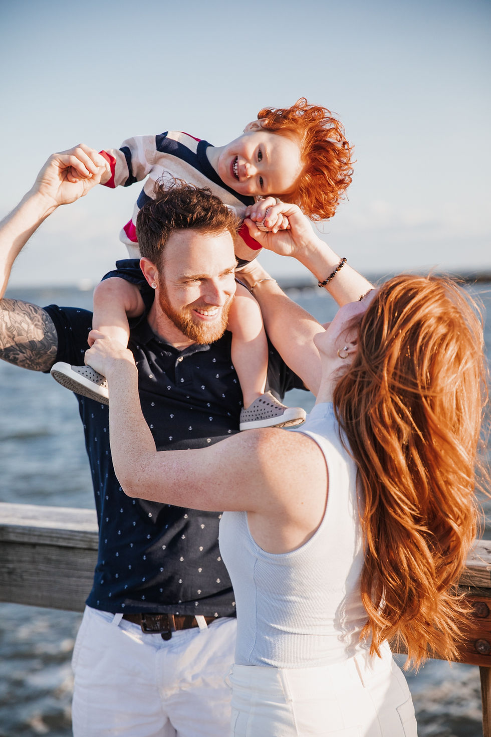 family of red heads laughing and playing on the beach in ocean city maryland
