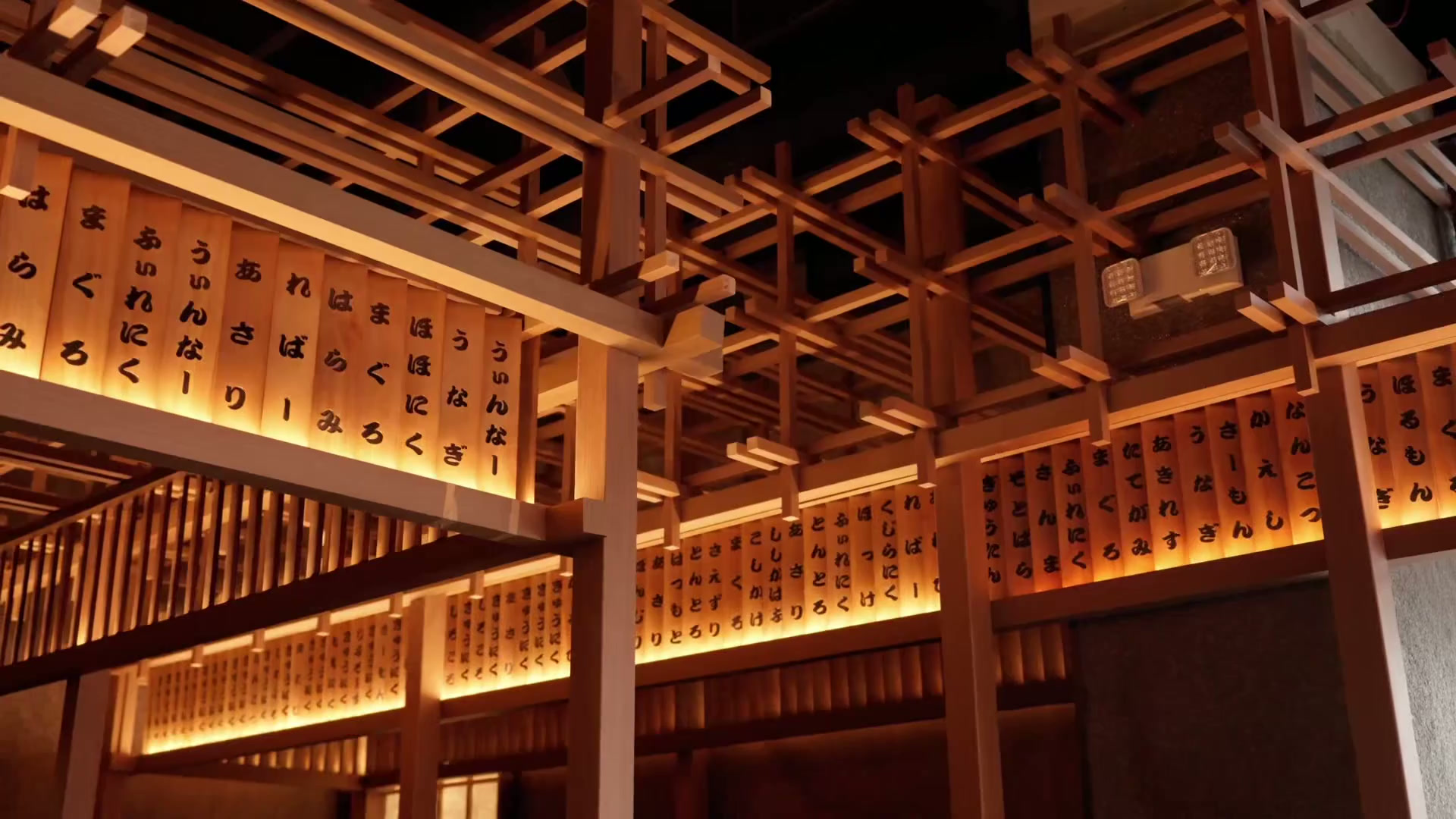 Gyusan's dining room, framed in pale wood slats and lit menu panels