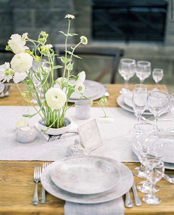 An ikebana style flower arrangement for a wedding table with seasonal white flowers