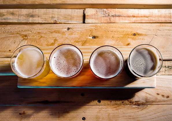 Top view of 4 beers in clear glass on a wood table