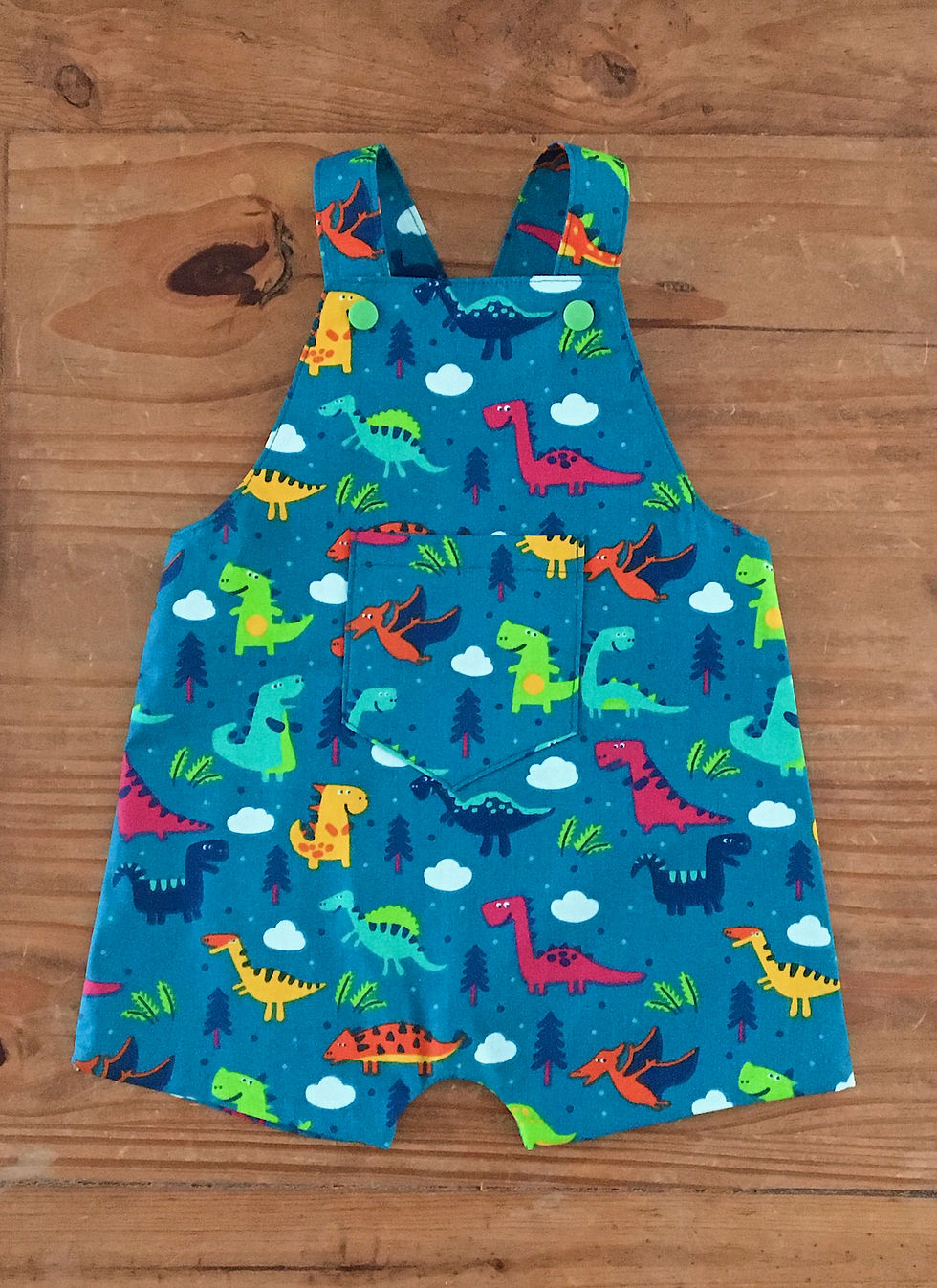 Thumbnail: Front view of handmade baby blue dinosaur shorts summer dungarees