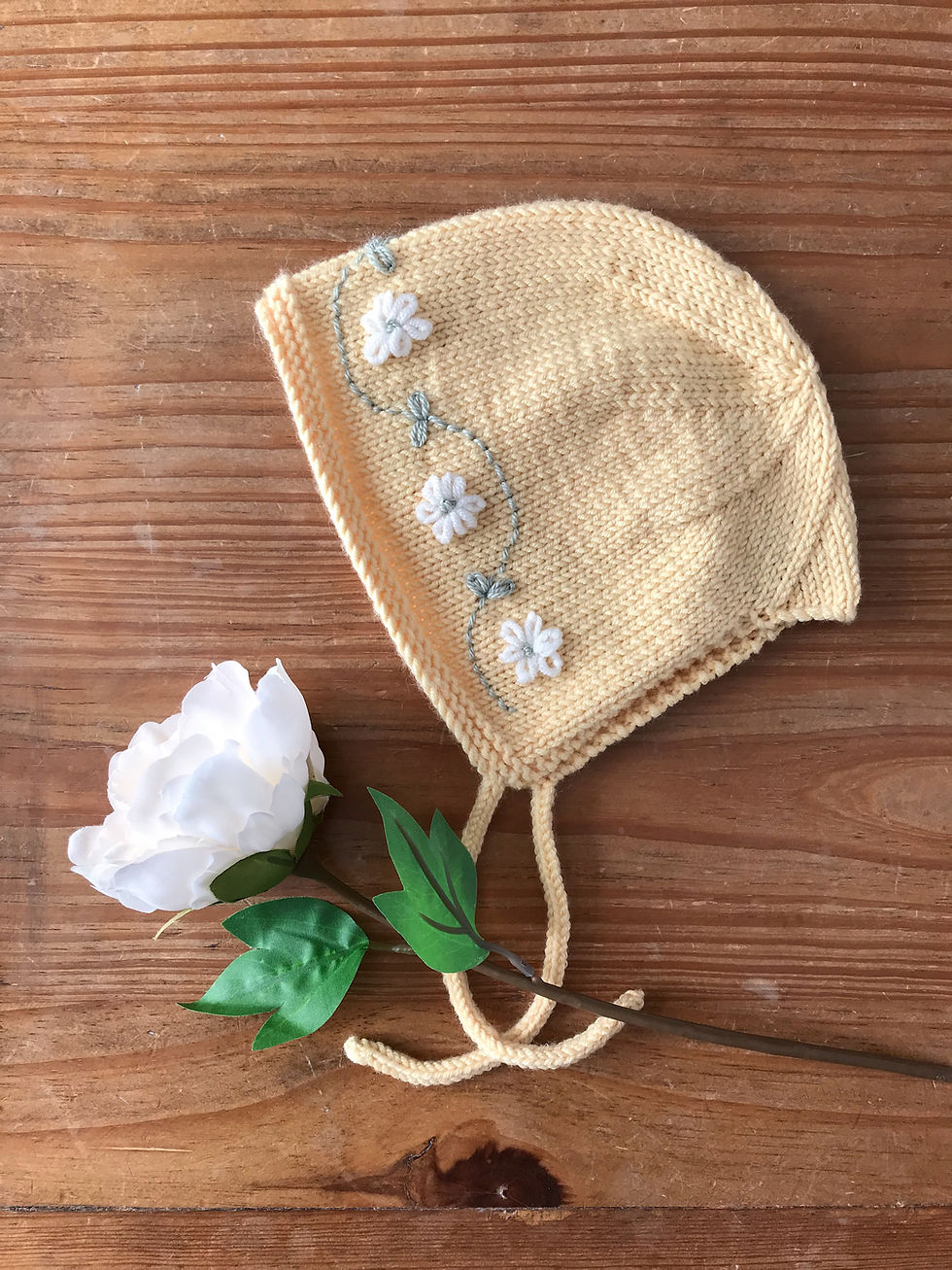 Thumbnail: Hand embroidered knitted baby bonnet in lemon yellow with floral embroidery