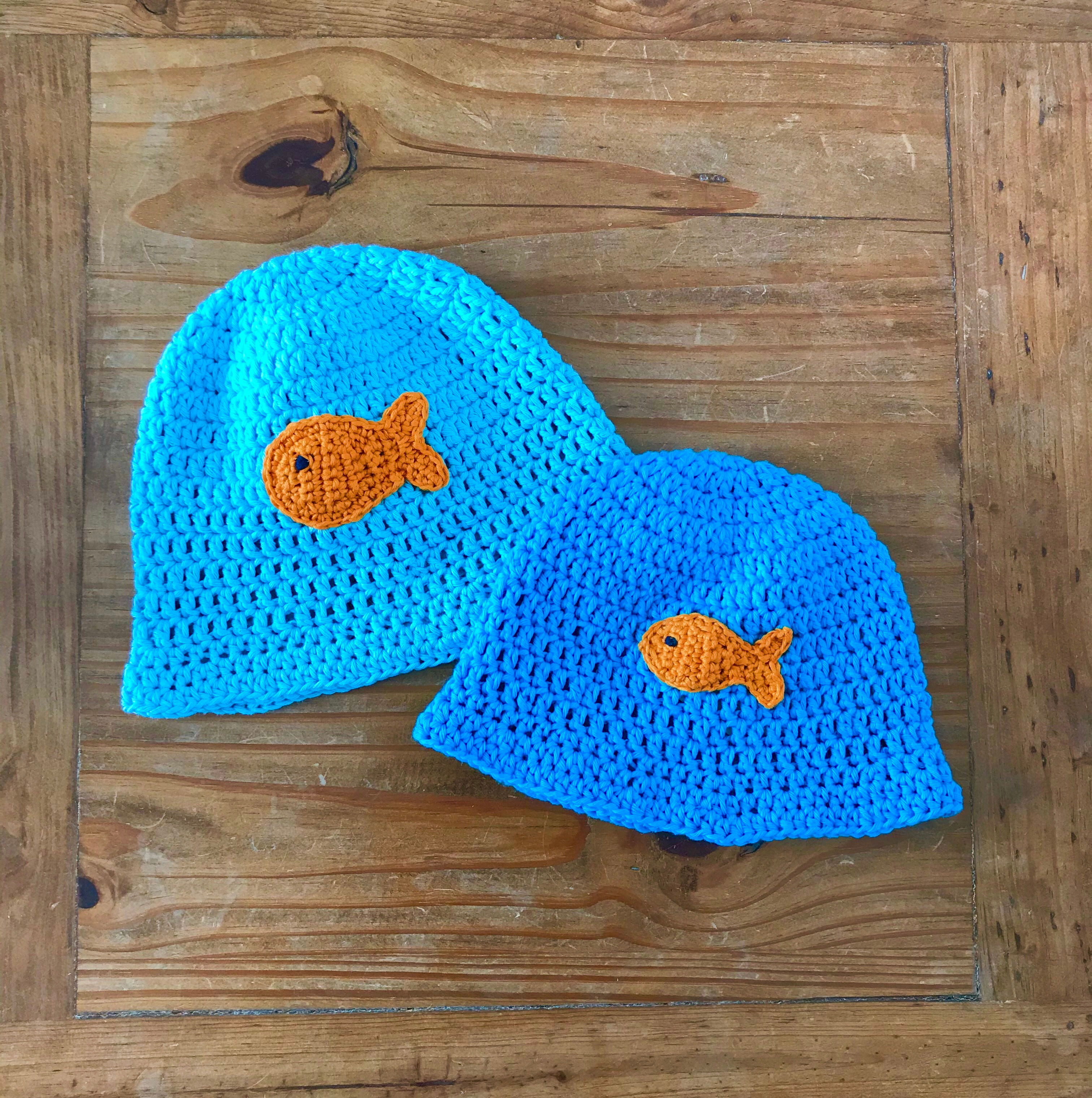Dark and pale turquoise crochet baby bucket hats with orange fish motif