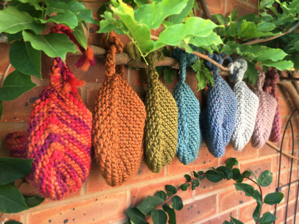 Thumbnail: Handmade knitted baby aviator hats hung up on a branch