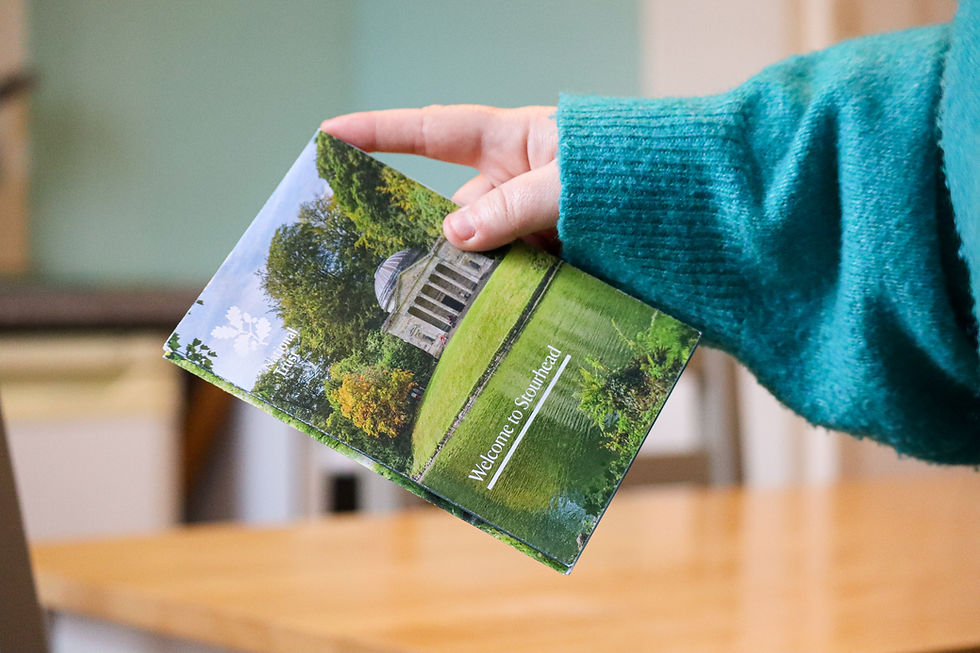 A hand holding a booklet showcasing the local area