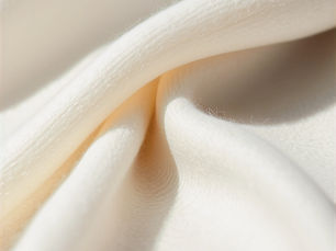 Close up of neutral toned cashmere fabric showing fine fiber texture and drape, representing conscious luxury fashion and material integrity.  Both are accessible, descriptive, and aligned with the article’s core argument.