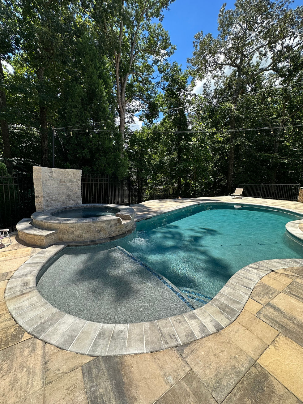 a large swimming pool with a hot tub and a waterfall