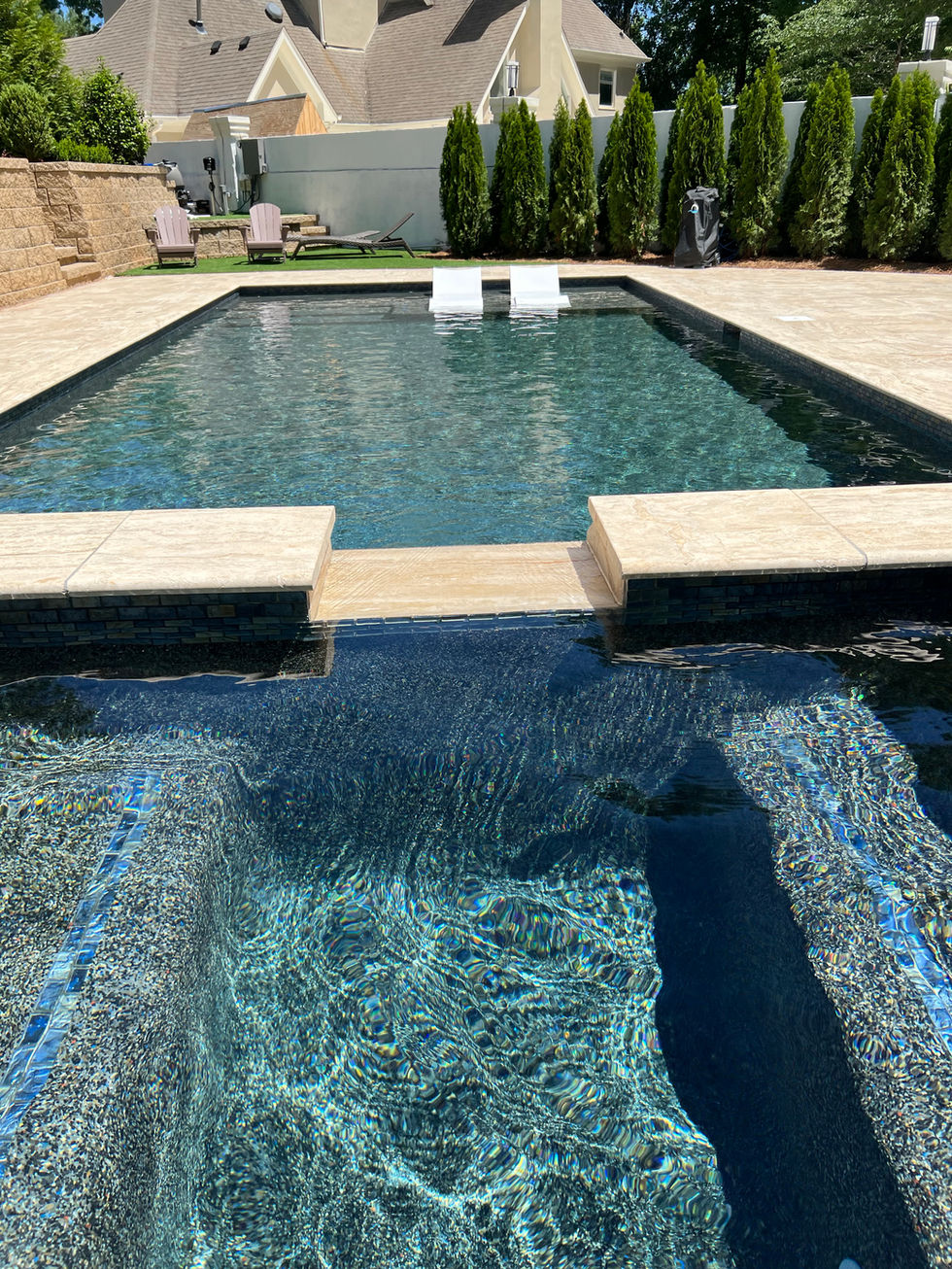 a large swimming pool with two chairs in it
