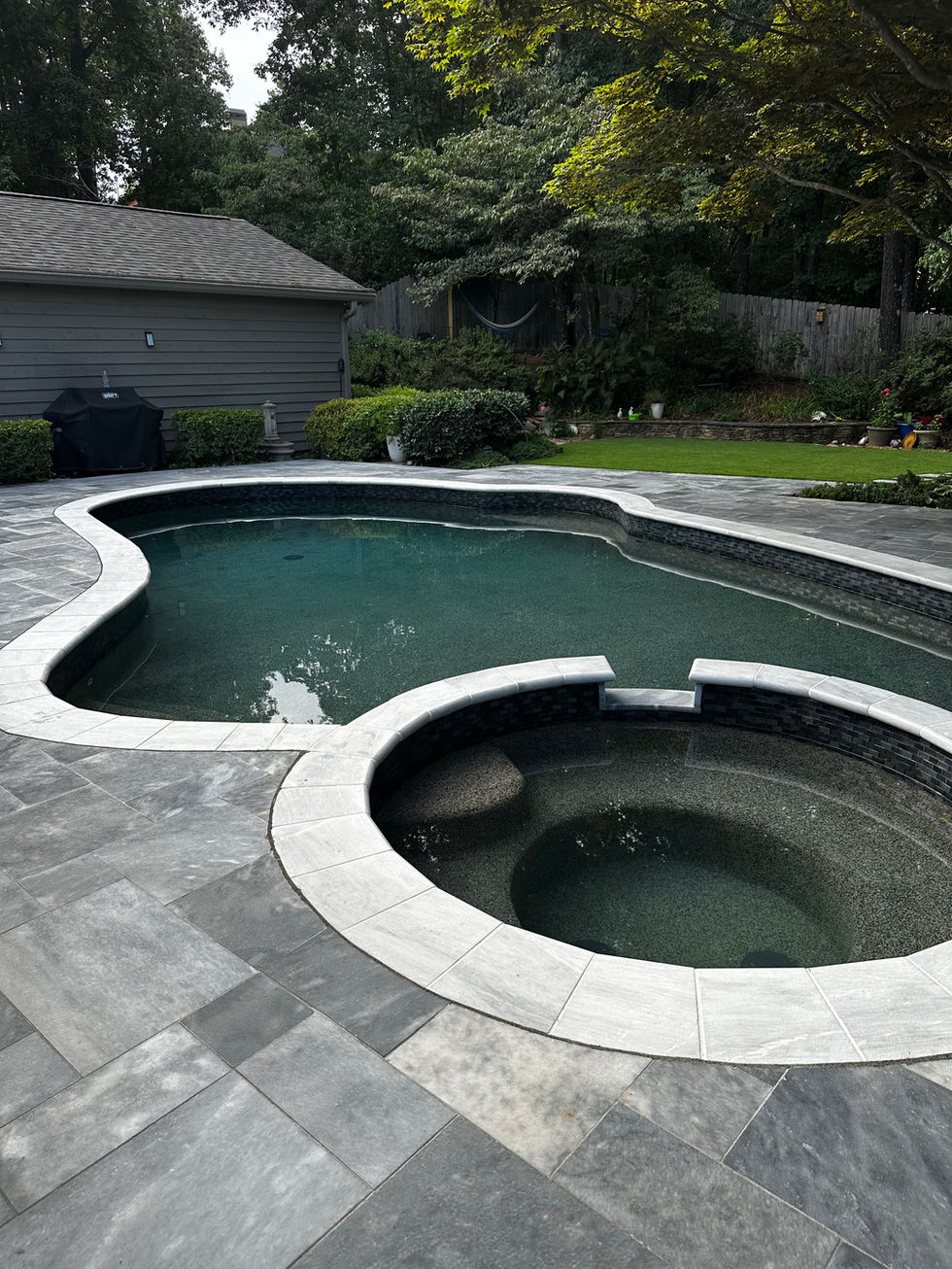 a large swimming pool with a hot tub in the middle