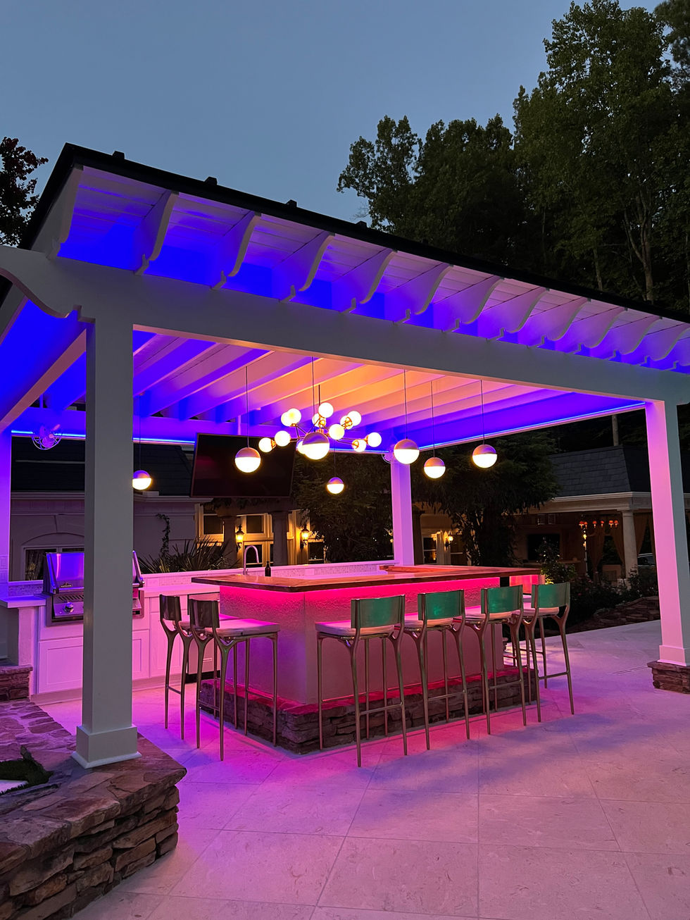 a pergola with a bar and stools underneath it