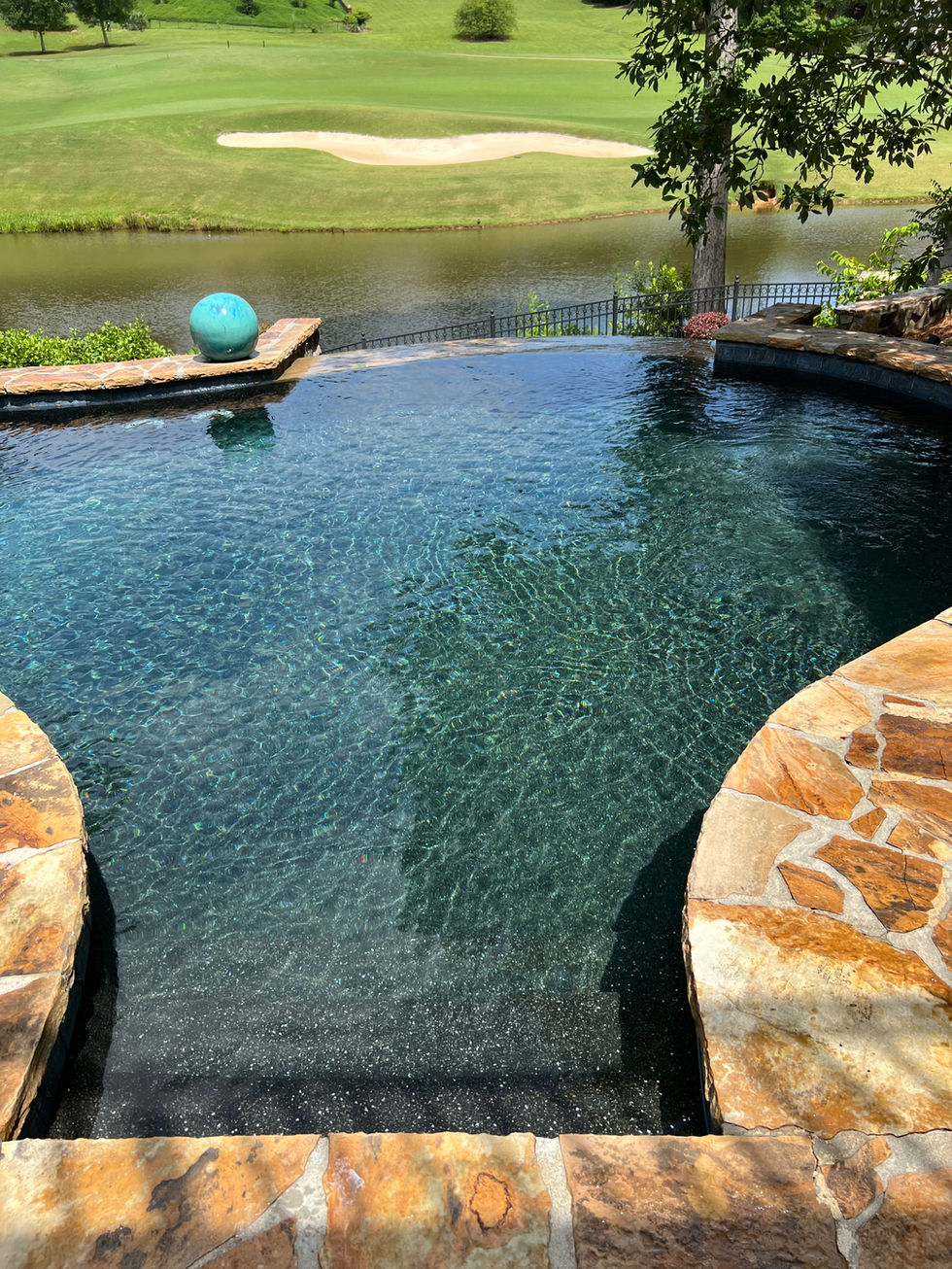 a swimming pool with a blue ball in the middle and a golf course in the background