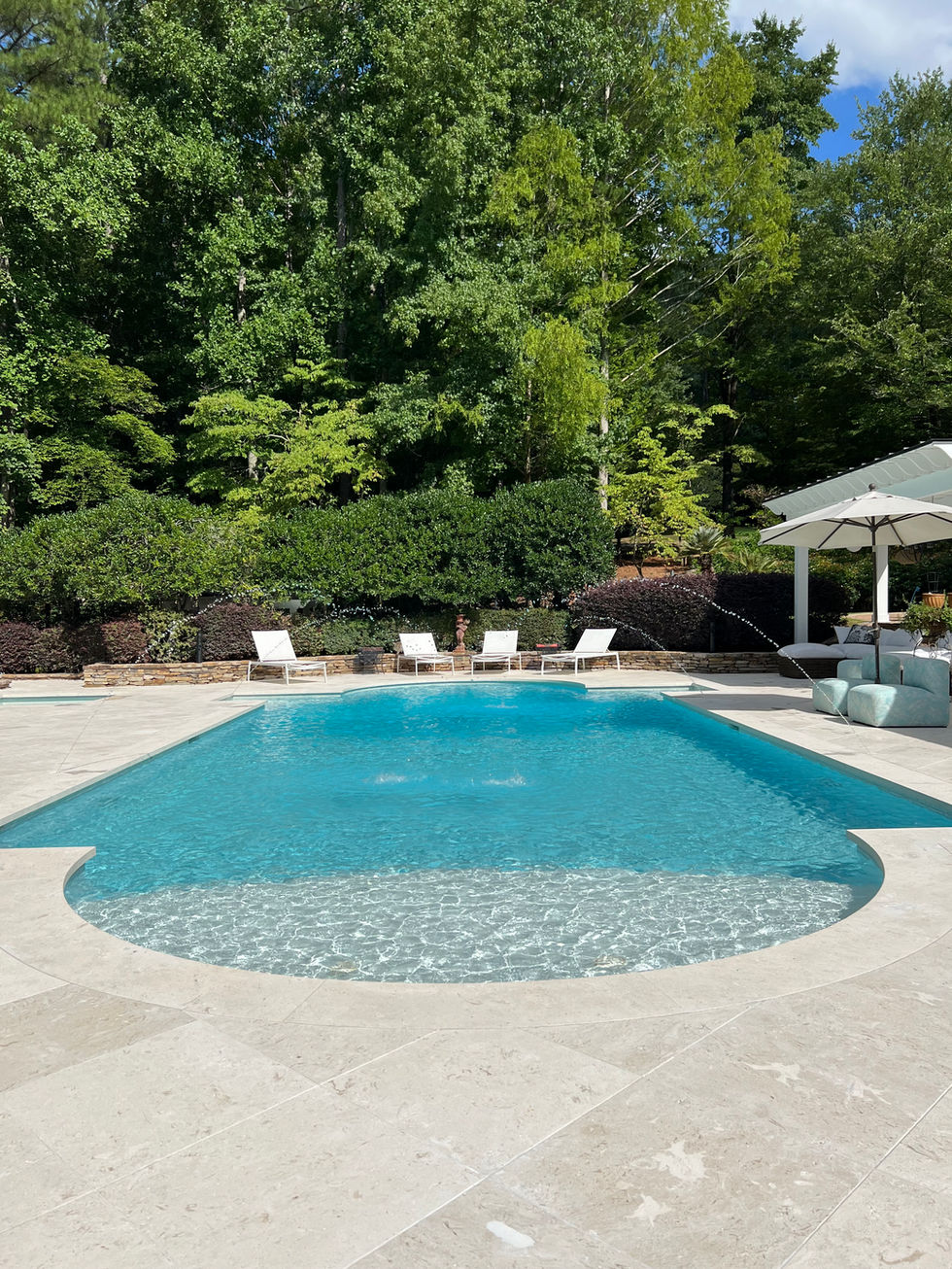 a large swimming pool surrounded by chairs and umbrellas