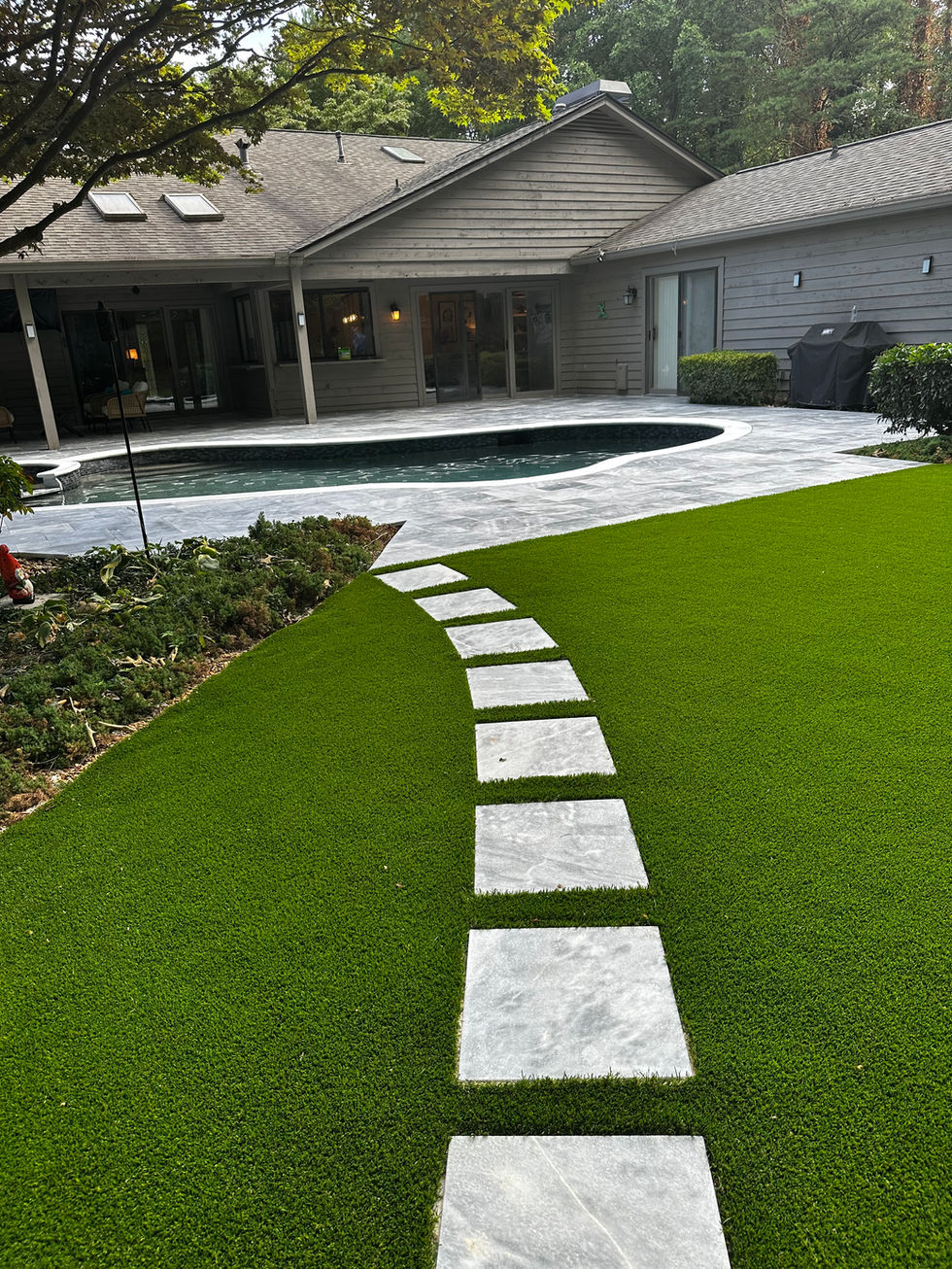 a lawn with a walkway leading to a pool