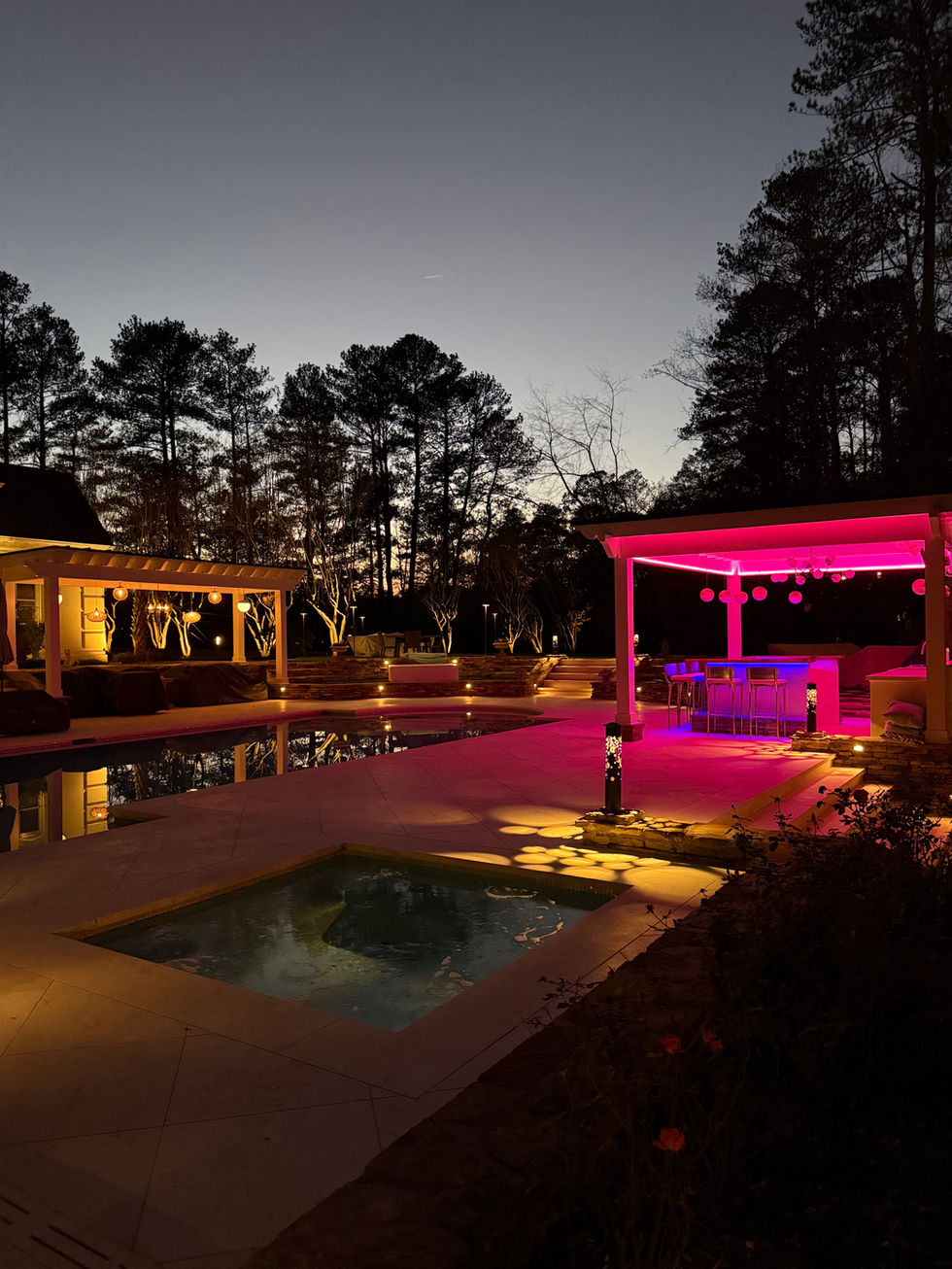 a large swimming pool is lit up at night