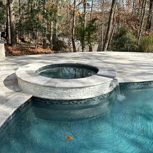 a swimming pool with a hot tub in the middle of it