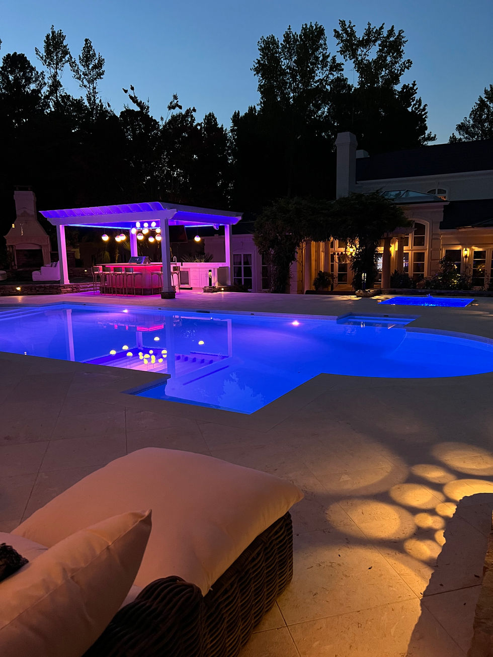 a large swimming pool is lit up at night