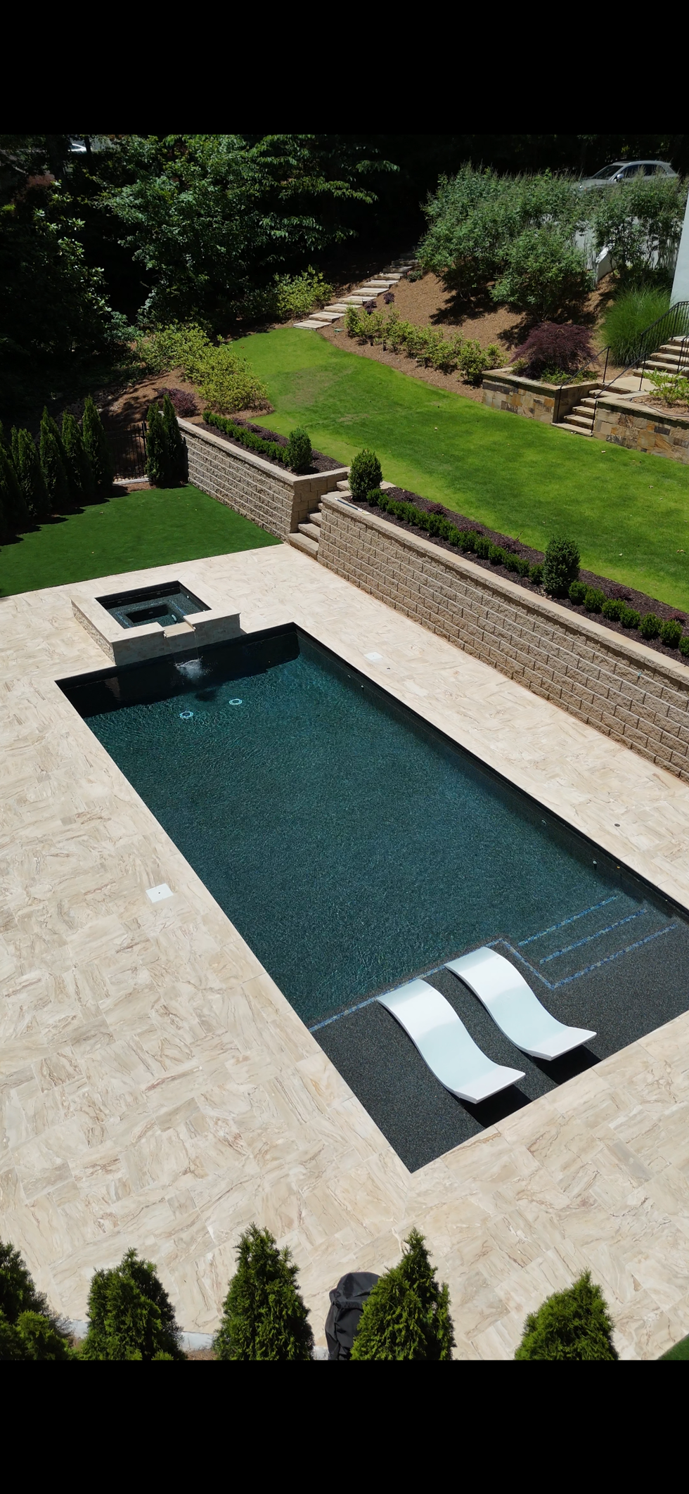 a large swimming pool with two lounge chairs in it