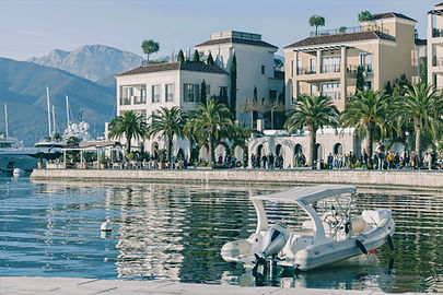 Luxury beachfronts houses with people on the street next to a river