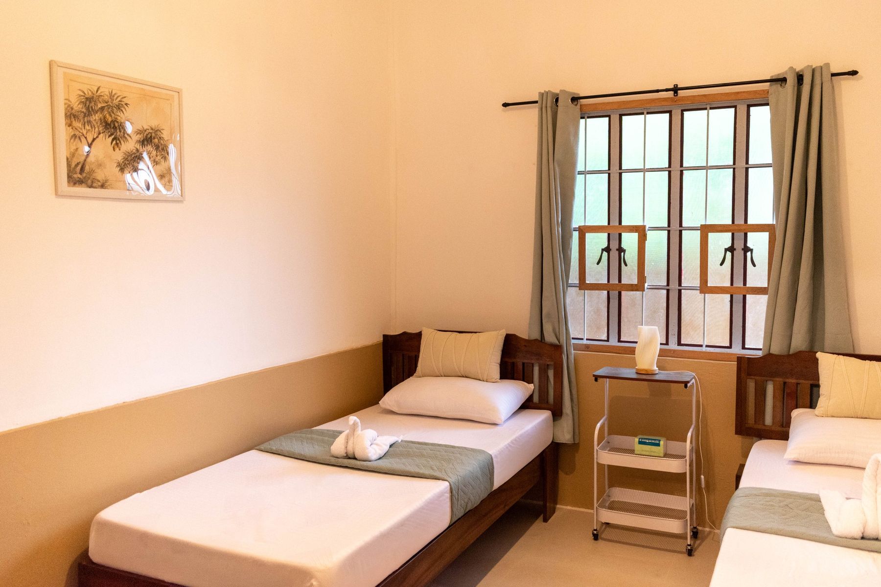 The same bedroom after the renovation, two single beds by the window