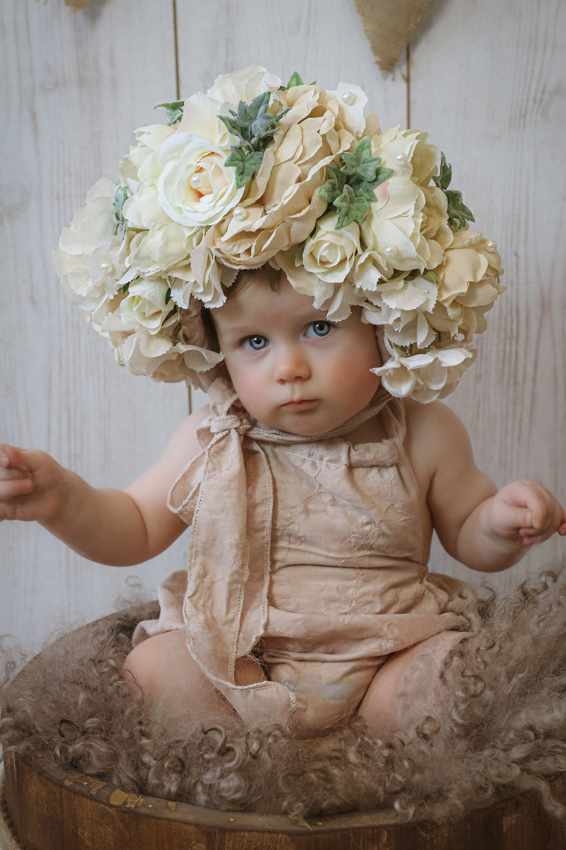 toddler girl wearing floral bonnet and pink romper suit