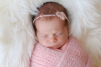 newborn girl asleep wearing pink