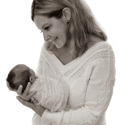 woman gazing lovingly down at her newborn baby