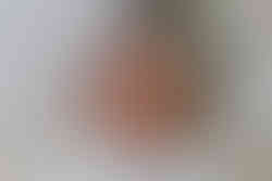 sleeping smiling newborn girl wearing white headband laying on white rug