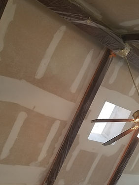 Close up of interior vaulted ceiling with skylight primed and ready to be painted