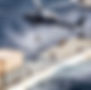 Military helicopter lowers soldier to cargo ship