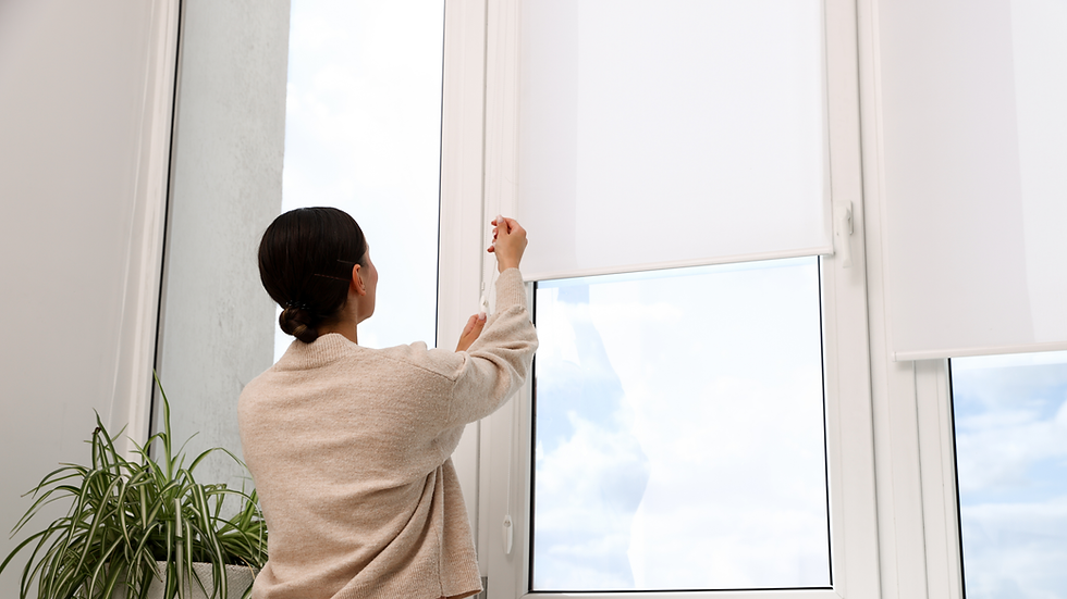 Woman adjusting white roller blind