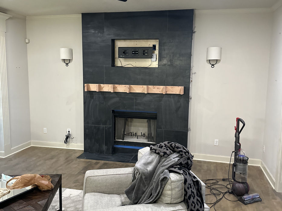 Living room with dark fireplace, armchair, and cat.