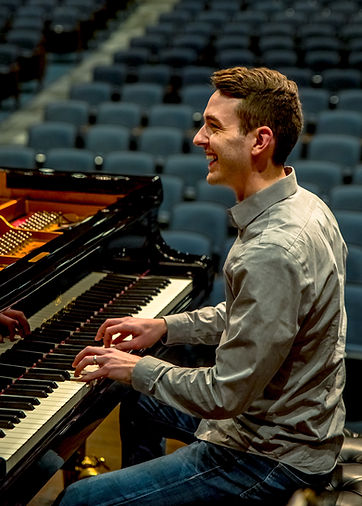 Tim Stephenson playing piano and smiling