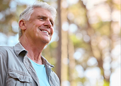 Senior man breathing deeply outdoors in nature, representing renewed vitality after heart treatment abroad for Canadian patients