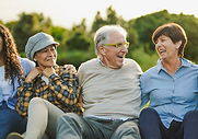 Healthy multigenerational group of adults laughing together outdoors, reflecting wellbeing after a comprehensive health check-up abroad
