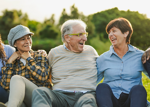 Healthy multigenerational group of adults laughing together outdoors, reflecting wellbeing after a comprehensive health check-up abroad